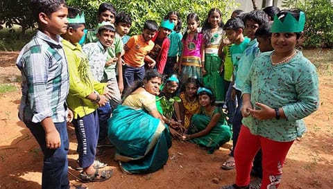 ஆசிரியைகள் மற்றும் மாணவர்கள் மரக்கன்றுகளை நட்டனர்.