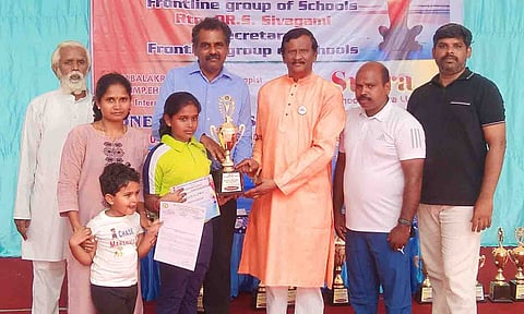 வெற்றி பெற்ற மாணவிக்கு பள்ளியின் தாளாளர் சிவசாமி கோப்பையை வழங்கிய காட்சி.