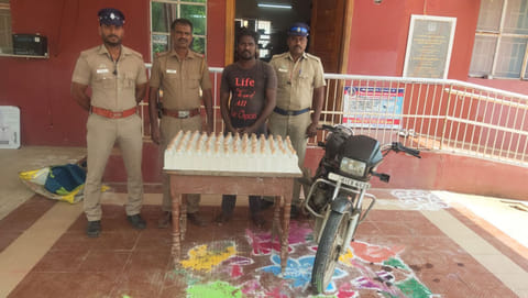 மதுபாட்டில்கள் கடத்தியதாக கைதான வாலிபரைபடத்தில் காணலாம்.