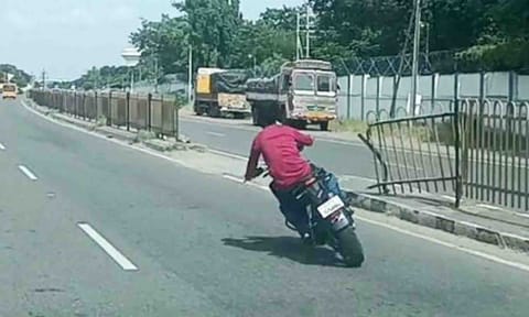 மோட்டார் சைக்கிள் சாகசத்தில் ஈடுபட் ட வாலிபரை படத்தில் காணலாம்.