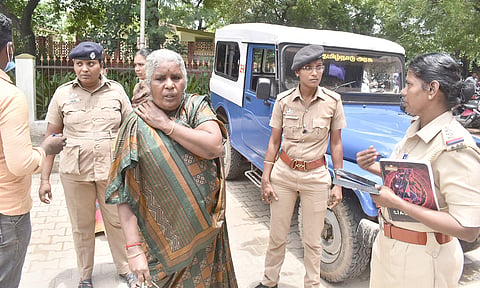 தீக்குளிக்க முயன்ற மூதாட்டியிடம் போலீசார் விசாரணை நடத்திய போது எடுத்த படம்.