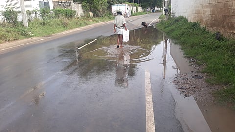 தேங்கி நிற்கும் மழைநீரில் நடந்து செல்லும் முதியவரை படத்தில் காணலாம்.