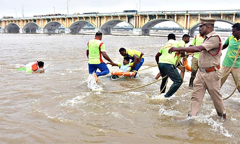 வைகை ஆற்றில் பேரிடர் மீட்பு குழு ஒத்திகையில் தண்ணீரில் மூழ்கியவரை காப்பாற்றும் காட்சி.