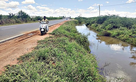 மதுரை-ராமேசுவரம் 4 வழி சாலையில் தடுப்புசுவர் இல்லாததால் தண்ணீர் செல்லும் கால்வாய்.