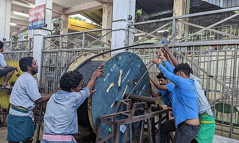 புதிய கம்பி வடக்கயிறு பொருத்தும் பணியில் ஈடுபட்டுள்ள ஊழியர்கள்.