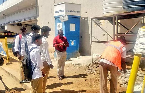 மாநகரட்சி ஊழியர் சுற்றியுள்ள பகுதிகளில் ப்ளீச்சிங் பவுடர் தூவிய காட்சி