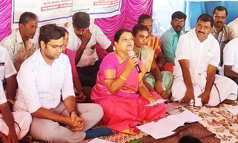 கிராம சபை கூட்டத்தில் அமைச்சர் கீதாஜீவன் பேசிய காட்சி. அருகில் மார்க்கண்டேயன் எம்.எல்.ஏ. உள்ளார்