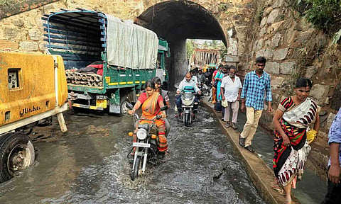 ரயில்வே பாலத்தில் மழைநீருடன் சாக்கடை கழிவுகள் கலந்து சாலையில் செல்வதை காணலாம்.&nbsp;