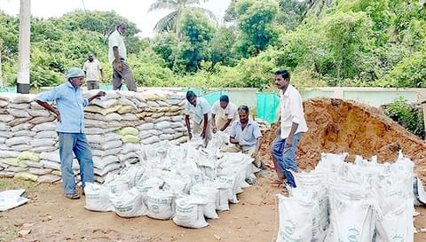 மணல் மூட்டைகளை தயார் செய்யும் பணியில் ஊழியர்கள்.