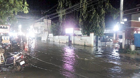 திருக்காட்டுப்பள்ளி கடைவீதியில் நேற்று இரவு பெய்த மழையால் தேங்கி நிற்கும் மழை நீர்.