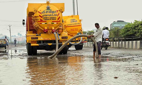 தேங்கி கிடக்கும் மழைநீரை அகற்றும் பணியில் ஈடுபட்டுள்ள மாநகராட்சியினரை படத்தில் காணலாம்.