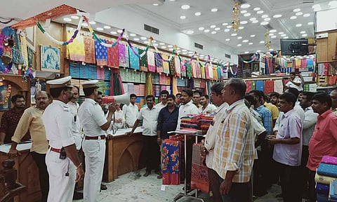 கடை ஊழியர்களிடம் போலீசார் அறிவுரை வழங்கிய காட்சி.