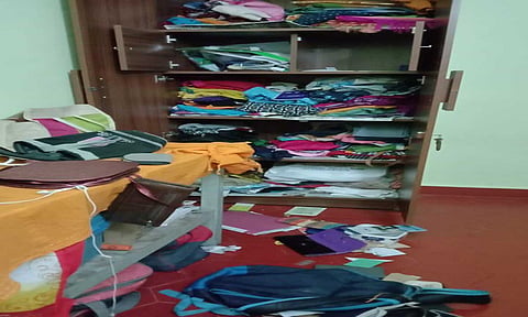 பீரோ உடைக்கப்பட்டு பொருட்கள் சிதறி கிடப்பதை படத்தில் காணலாம்