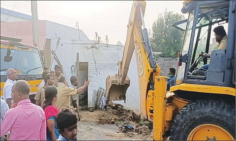 ஆக்கிரமித்து கட்டியிருந்த வீடுகளை பொக்லைன் எந்திரம் மூலம் அகற்றிய காட்சி.