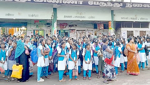 பஸ்சுக்காக நிலையத்தில் காத்திருக்கும் மாணவ-மாணவிகள்.