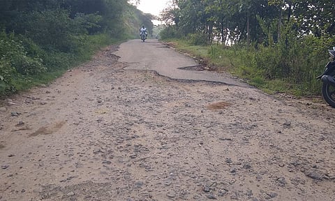 குண்டும் குழியுமாக கிடக்கும் சாலை.