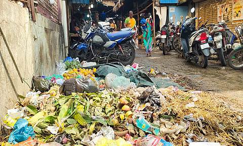 பூ மார்க்கெட்டில் குவிந்து கிடக்கும் குப்பைகளை படத்தில் காணலாம்.&nbsp;