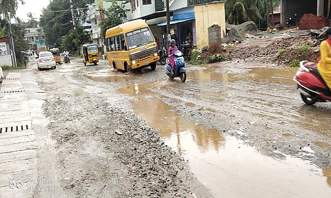பழுதடைந்த சாலையில் வாகனங்கள் சிரமபட்டு செல்லும் காட்சி