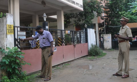 சம்பவம் நடந்த அடுக்குமாடி குடியிருப்பின் இரும்பு கேட்டை போலீசார் ஆய்வு செய்த காட்சி