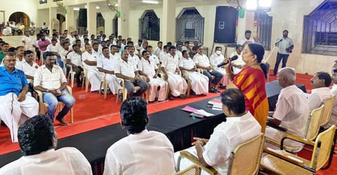 கூட்டத்தில் அமைச்சர் கீதாஜீவன் பேசிய காட்சி. அருகில் மார்க்கண்டேயன் எம்.எல்.ஏ. உள்ளார்.