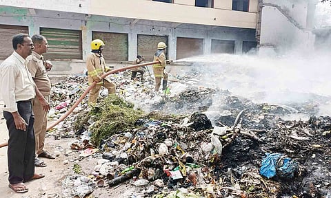 குப்பை கிடங்கில் தீயை அணைக்கும் வீரர்களை படத்தில் காணலாம்.