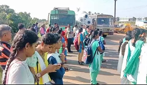 பஸ் பழுதானதால் சாலையில் காத்திருந்த மாணவ-மாணவிகளை படத்தில் காணலாம்.