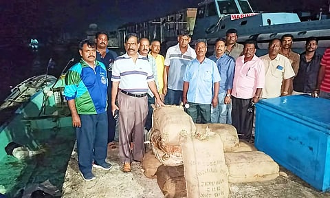 பறிமுதல் செய்யப்பட்ட கஞ்சா மூட்டைகளுடன் சுங்கதுறை அதிகாரிகள்