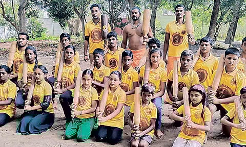 கர்லா கட்டை சுற்றும் கின்னஸ் சாதனை நிகழ்ச்சியில் பங்கேற்கும் மாணவ-மாணவிகள்.