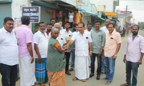 மங்கலம் ஊராட்சி மன்றத்தலைவர் எஸ்.எம்.பி.மூர்த்தி பொதுமக்களுக்கு இனிப்பு வழங்கிய காட்சி.&nbsp;