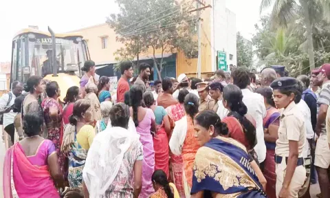 பொக்லைன் எந்திரத்தின் மீது ஏறி பெண்கள் ஆர்ப்பாட்டம் செய்த காட்சி.