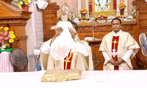 இயேசுநாதர் பிறந்தார் என்பதை குழந்தை இயேசு சுரூபத்தை உயர்த்தி காண்பித்து அறிவிக்கும் பூண்டி மாதா பேராலய அதிபர் சாம்சன்.
