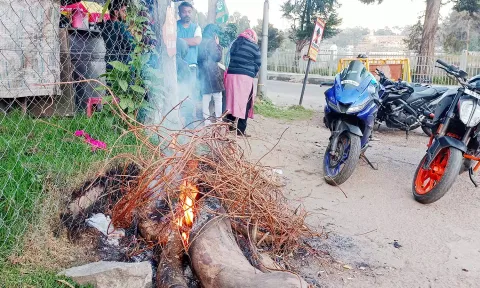 ஏரிச்சாலை ஜிம்கானா மைதானம் அருகே தீமூட்டி குளிர்காயும் பொதுமக்கள்.