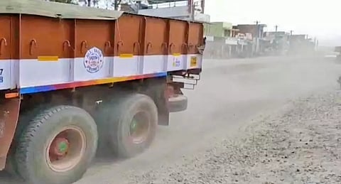 சாலையில் புழுதிகள் பறப்பதை படத்தில் காணலாம்