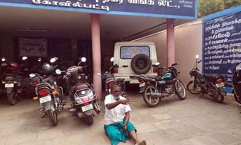 கூட்டுறவு வங்கி வாசலில் ராஜேந்திரன் தர்ணாவில் ஈடுபட்ட காட்சி.