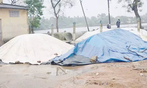 கொள்முதல் நிலையம் முன்பு நெல்லை கொட்டி தார்பாய் கொண்டு மூடி வைத்துள்ள விவசாயிகள்.