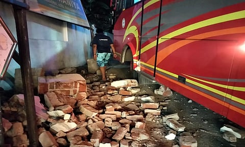 பஸ்சின் மீது நுழைவு வாயிலின் மேல் பகுதி உடைந்து விழுந்துள்ளதை படத்தில் காணலாம்&nbsp;