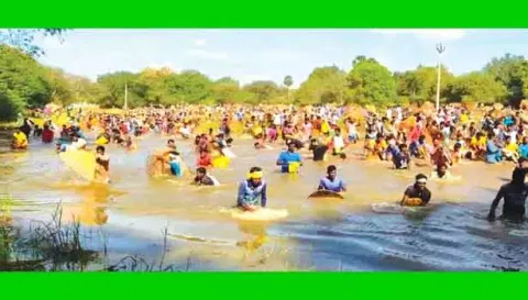 கண்மாய்க்குள் இறங்கி மீன்பிடித்த கிராம மக்கள்.
