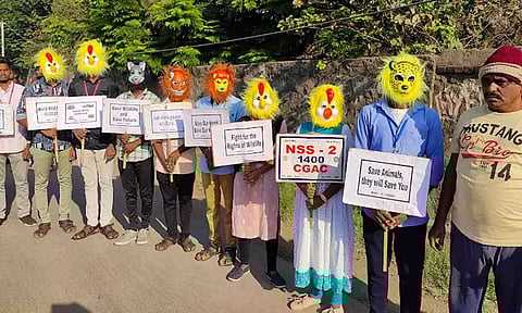 வனவிலங்குகள் பாதுகாப்பை வலியுறுத்தி   முகமூடி அணிந்து, மனித சங்கிலி அமைத்தும் விழிப்புணர்வு ஏற்படுத்திய காட்சி.