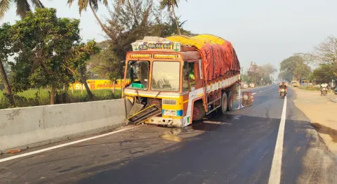 வரக்கால்பட்டு சாலையில் சிமெண்ட் தடுப்பு கட்டையில் லாரி மோதி நிற்கும் காட்சி.