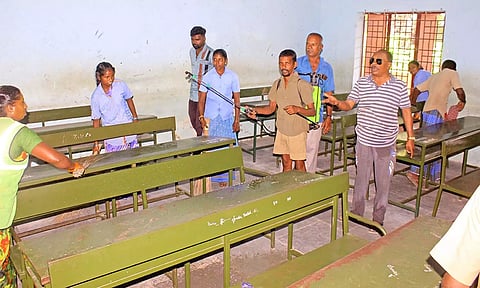 டவுன் கல்லணை பள்ளியில் உள்ள தேர்வு எழுதும் வகுப்பறையை தூய்மை பணியாளர்கள் சுத்தம் செய்த காட்சி.