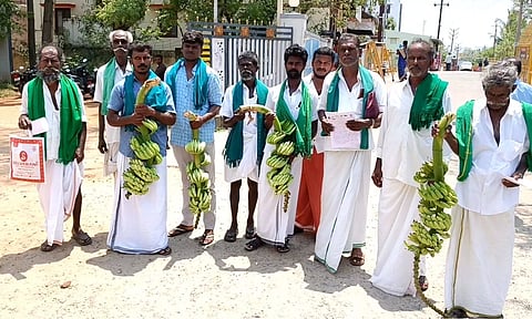 வாழைத்தார்களுடன் மனு அளிக்க வந்த விவசாயிகள்.