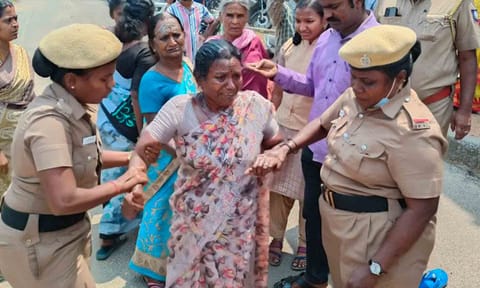 ஜான்சி தீக்குளிக்க முயன்றதையும் போலீசார் தடுத்து நிறுத்தியதையும் படத்தில் காணலாம்.&nbsp;