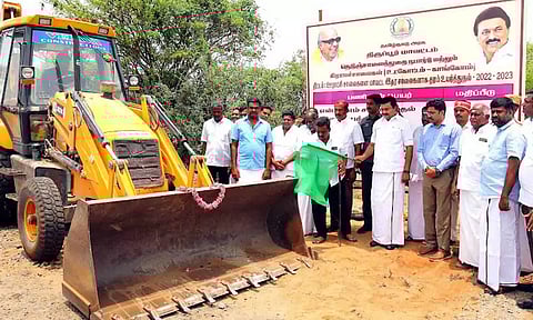 சாலை தரம் உயர்த்தும் பணியை அமைச்சர் மு.பெ.சாமிநாதன் தொடங்கி வைத்த காட்சி. அருகில் கலெக்டர் வினீத் மற்றும் பலர்  உள்ளனர்.&nbsp; &nbsp;