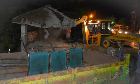 சாலை விரிவாக்கப் பணிக்காக கடலூர் ஆல்பேட்டையில் இருந்த பயணியர் நிழற்குடை நேற்று நள்ளிரவில் இடிக்கப்படும் காட்சி.