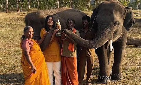 ஆஸ்கர் விருதுடன் ‘போஸ்’ கொடுக்கும் யானைகள் மற்றும் பாகன் தம்பதி. அருகில் இயக்குனர் கார்த்திகி கோன்சால்வ்ஸ் உள்ளார்.
