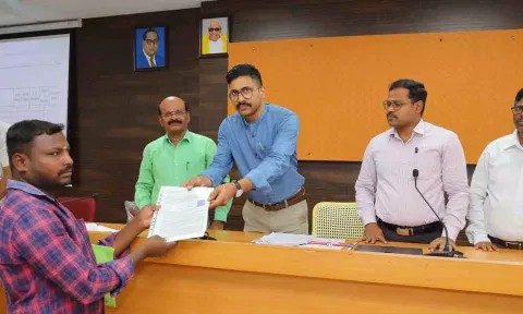 பயனாளிகளுக்கு விலையில்லா வீட்டுமனை பட்டாக்களை  கலெக்டர் வினீத்  வழங்கிய காட்சி.