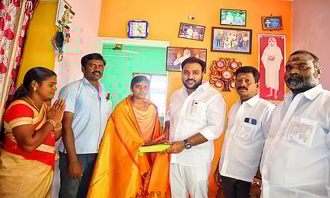 செஞ்சி பேரூராட்சி மன்ற தலைவர் மொக்தியார் மஸ்தான் மாணவி ஒருவருக்கு சால்வை அணிவித்து இனிப்பு வழங்கிய காட்சி.&nbsp;