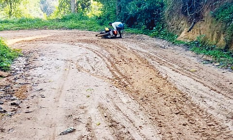 சேறும் சகதியுமாக மாறிய சாலையில் வழுக்கி விழுந்த வாகன ஓட்டியை படத்தில் காணலாம்.