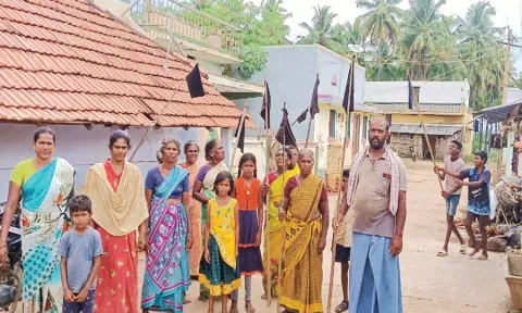 கருப்பு கொடியுடன் போராட்டத்தில் ஈடுபட்ட கிராம மக்கள்.