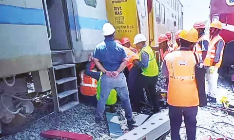 மாடி ரெயில் தடம் புரண்ட இடத்தில் மீட்பு பணி நடப்பதை படத்தில் காணலாம்.